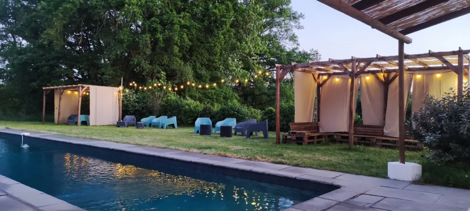 La piscine au soleil couchant, transats et guirlandes